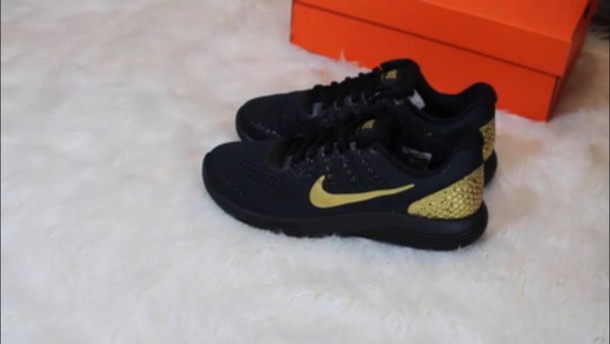 black nike shoes with gold nike sign